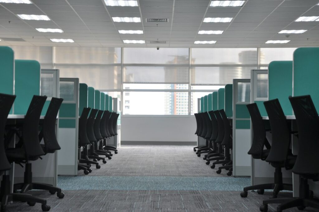 Sedie e postazioni di lavoro vuote in un ufficio open space, contesto di Covid e stress sul lavoro
