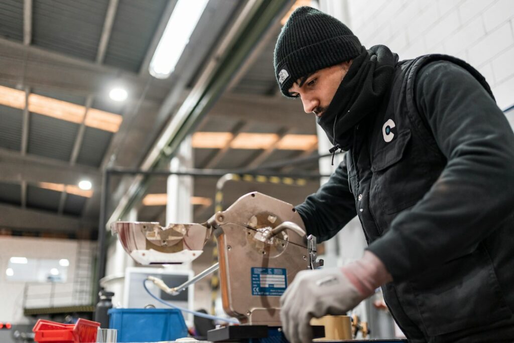 Operatore che utilizza un utensile da taglio in officina indossando i dispositivi di protezione previsti per la sicurezza e l'igiene sui luoghi di lavoro