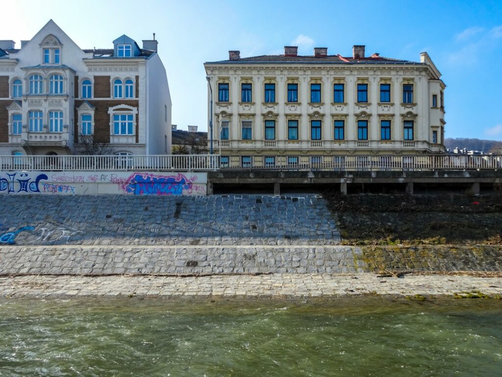 Edifici affacciati su un fiume con argine in pietra, opera di difesa contro i rischi idrogeologici