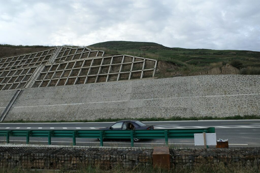 Muro di sostegno lungo una strada a protezione del versante, opera tipica della valutazione del rischio da frana