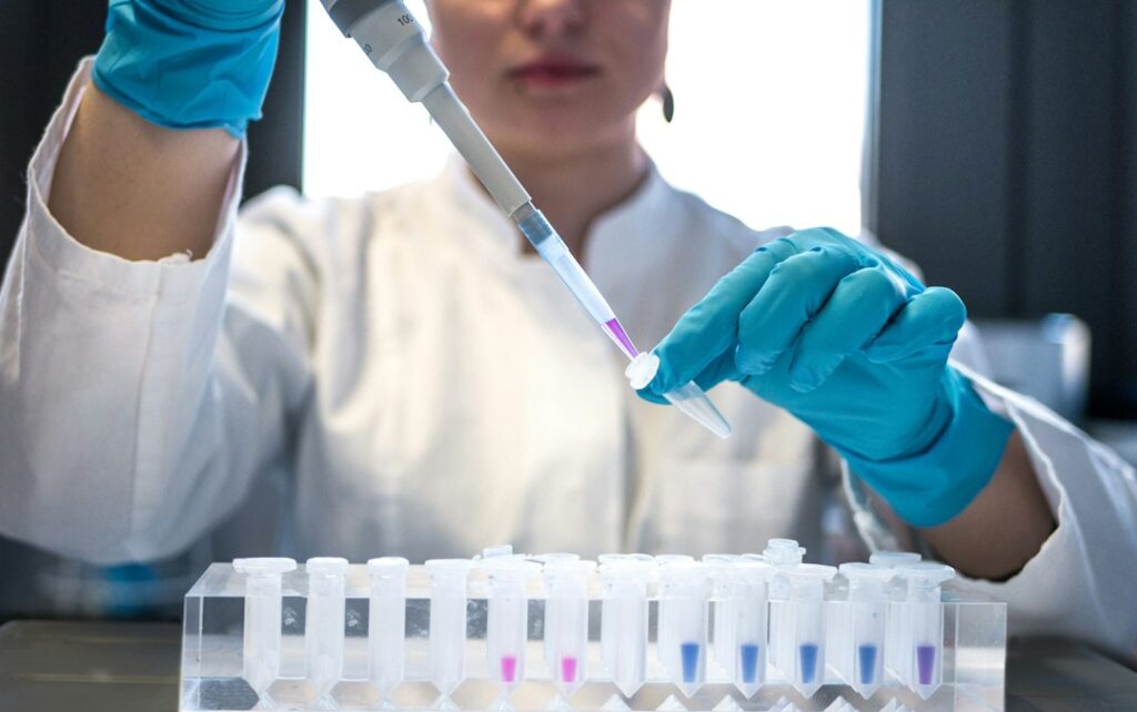 Tecnica di laboratorio dosa reagenti con la pipetta in provetta durante le analisi ambientali