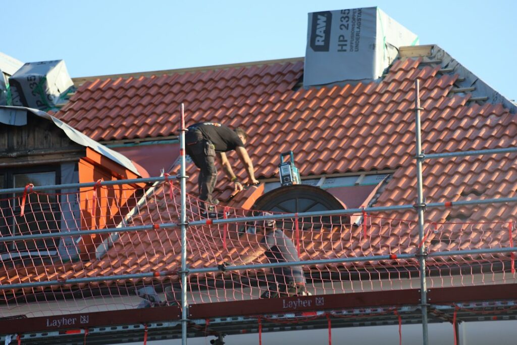 Operai impegnati nel rifacimento della copertura di un edificio, intervento tipico della gestione del problema amianto