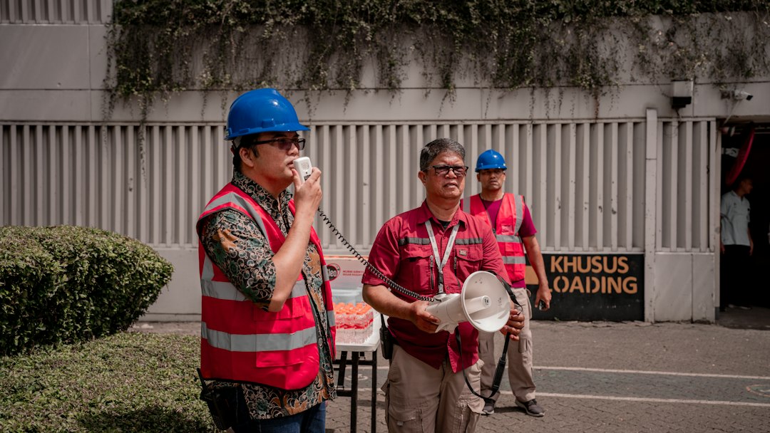Lavoratori con casco e gilet alta visibilità durante un confronto sulla sicurezza sul lavoro in cantiere