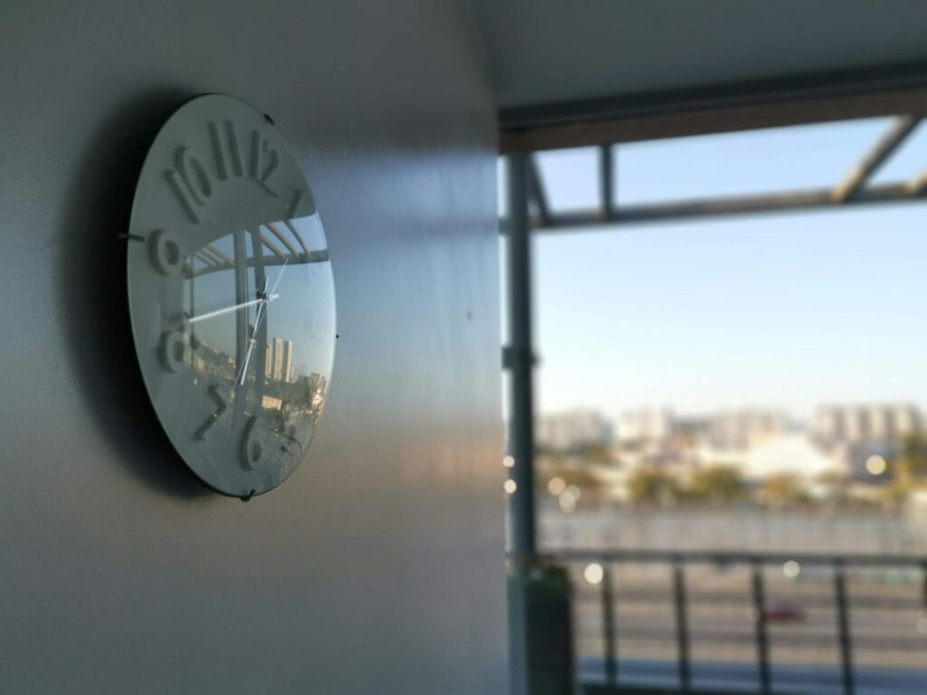 Orologio appeso alla parete di un ufficio a fine giornata lavorativa, immagine del tempo di lavoro legato a stress e rischi psicosociali