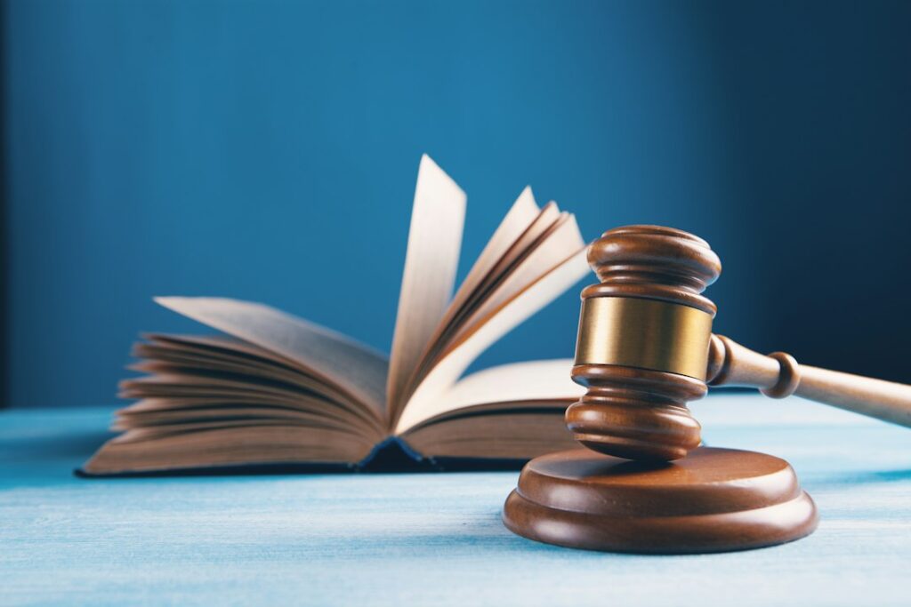 Martelletto del giudice accanto a un libro aperto su un tavolo, sentenze sulle responsabilità penali dell'RSPP