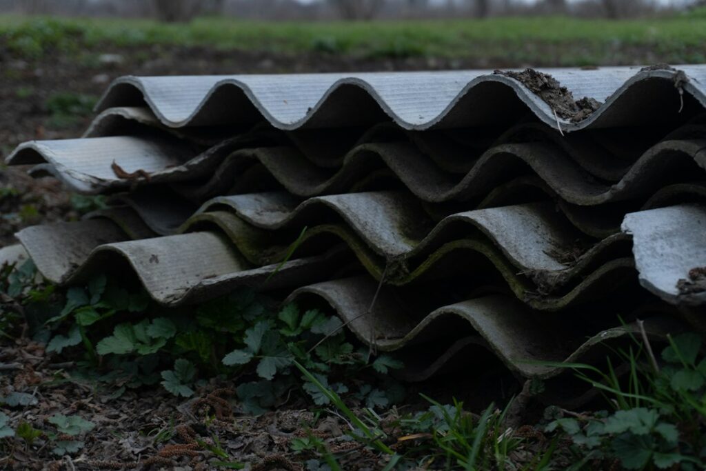 Pila di lastre ondulate in cemento-amianto deteriorate, materiale contenente amianto