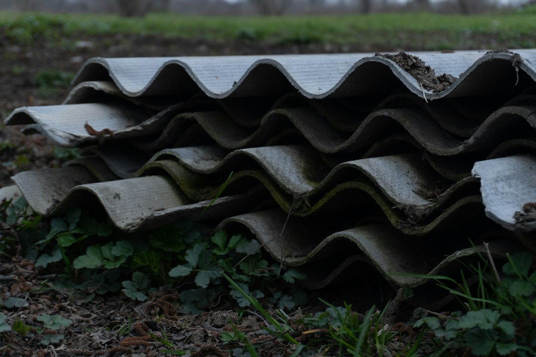 Pila di lastre ondulate in cemento-amianto deteriorate, materiale contenente amianto